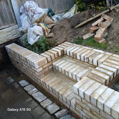 Hitchin cream brick retaining wall build Cream brick retaining garden wall under construction in Hitchin